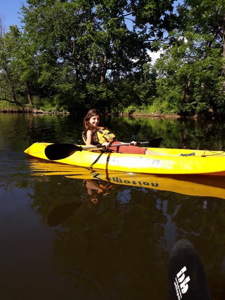student sitting in a yellow kayak
