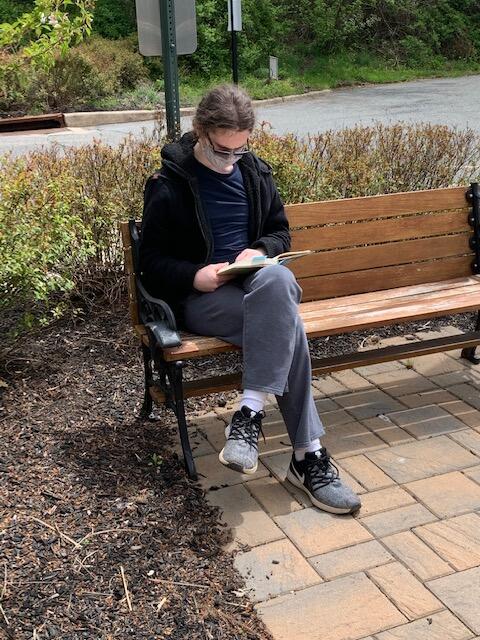student sitting on a bench reading