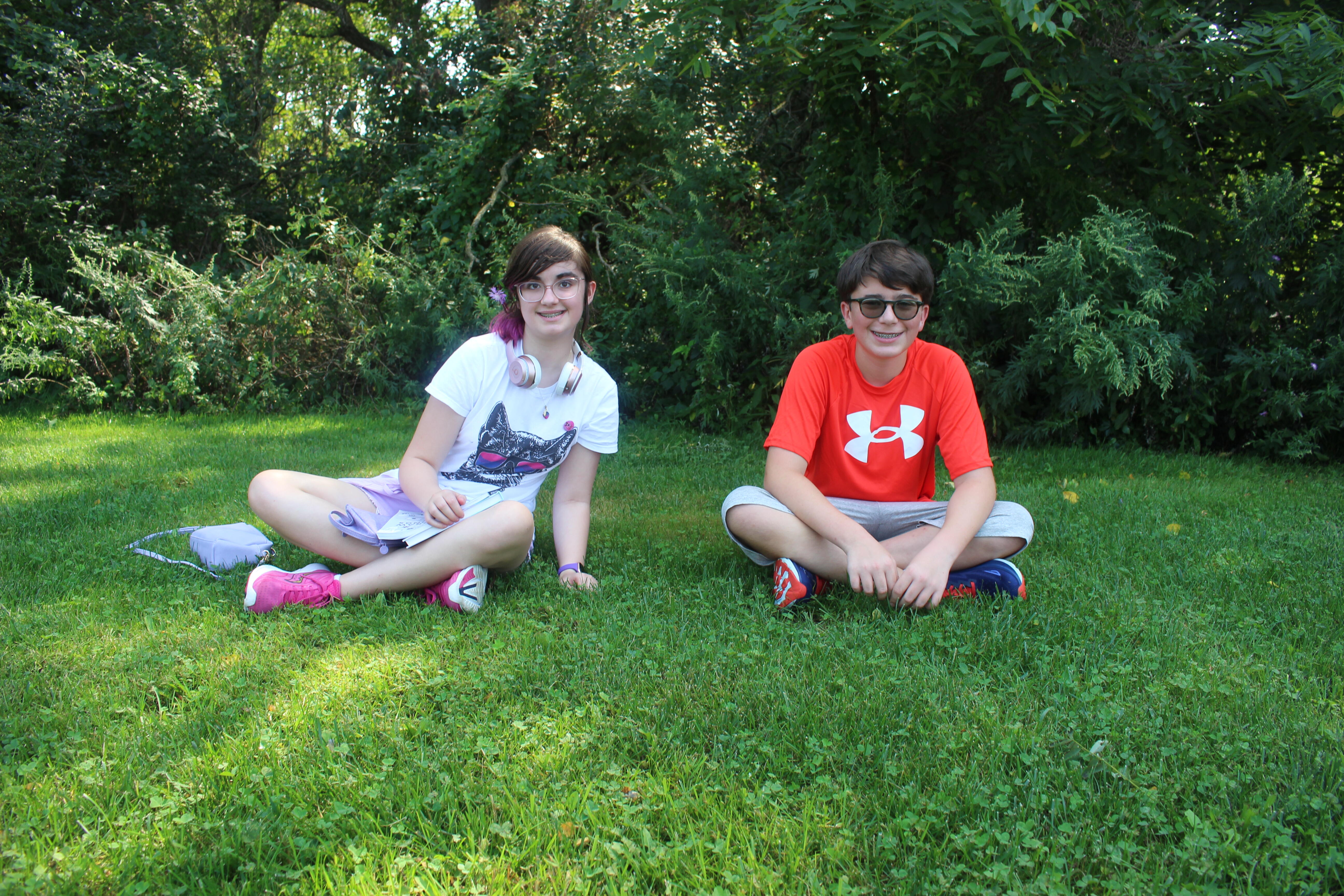 two students sitting in the grass