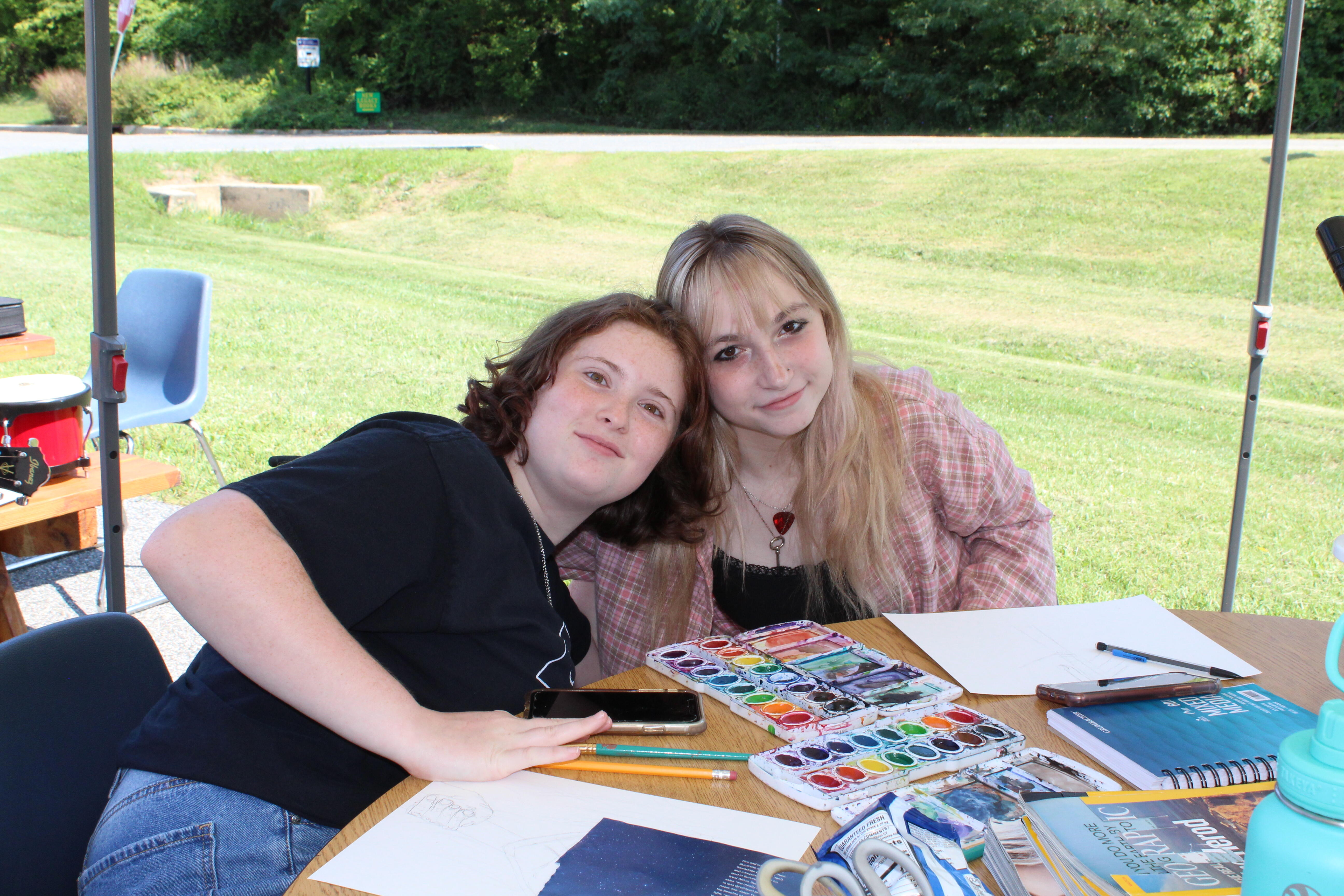 two students doing art at a table