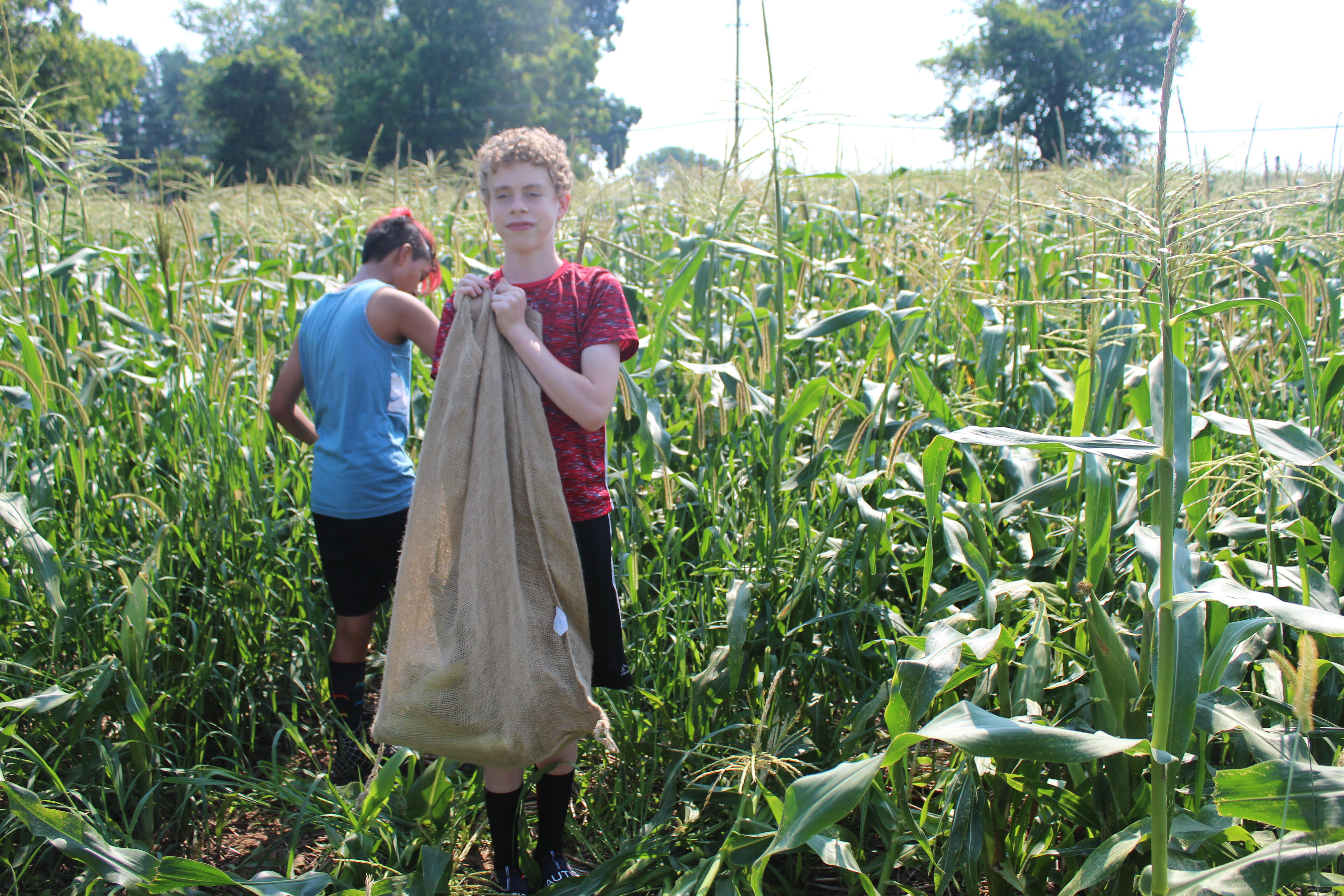 student holding bag of corn